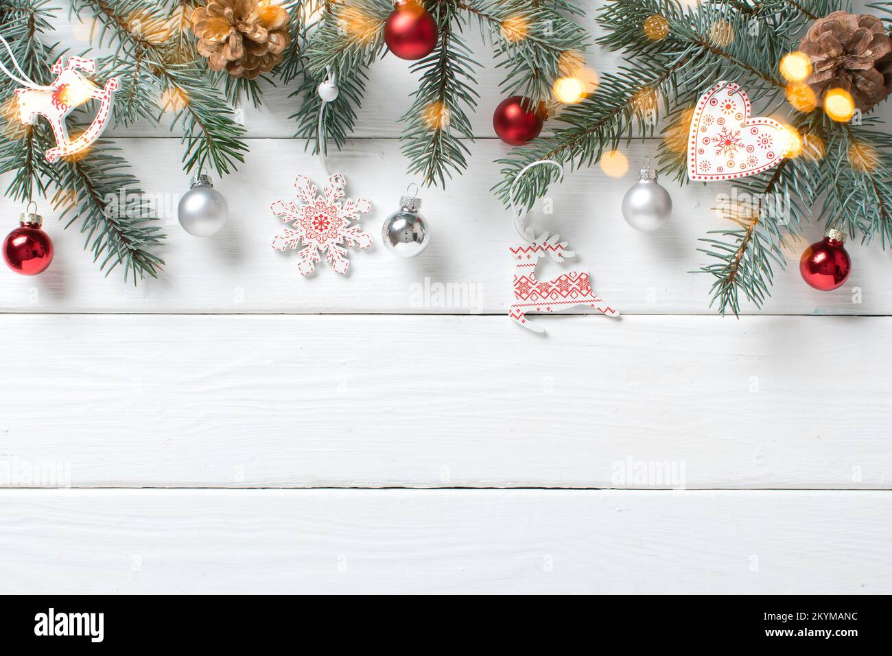 Branches de sapin et boules de verre avec bokeh sur fond blanc en bois. Minimalisme de Noël. Espace pour la copie. Position plate, vue de dessus. Banque D'Images