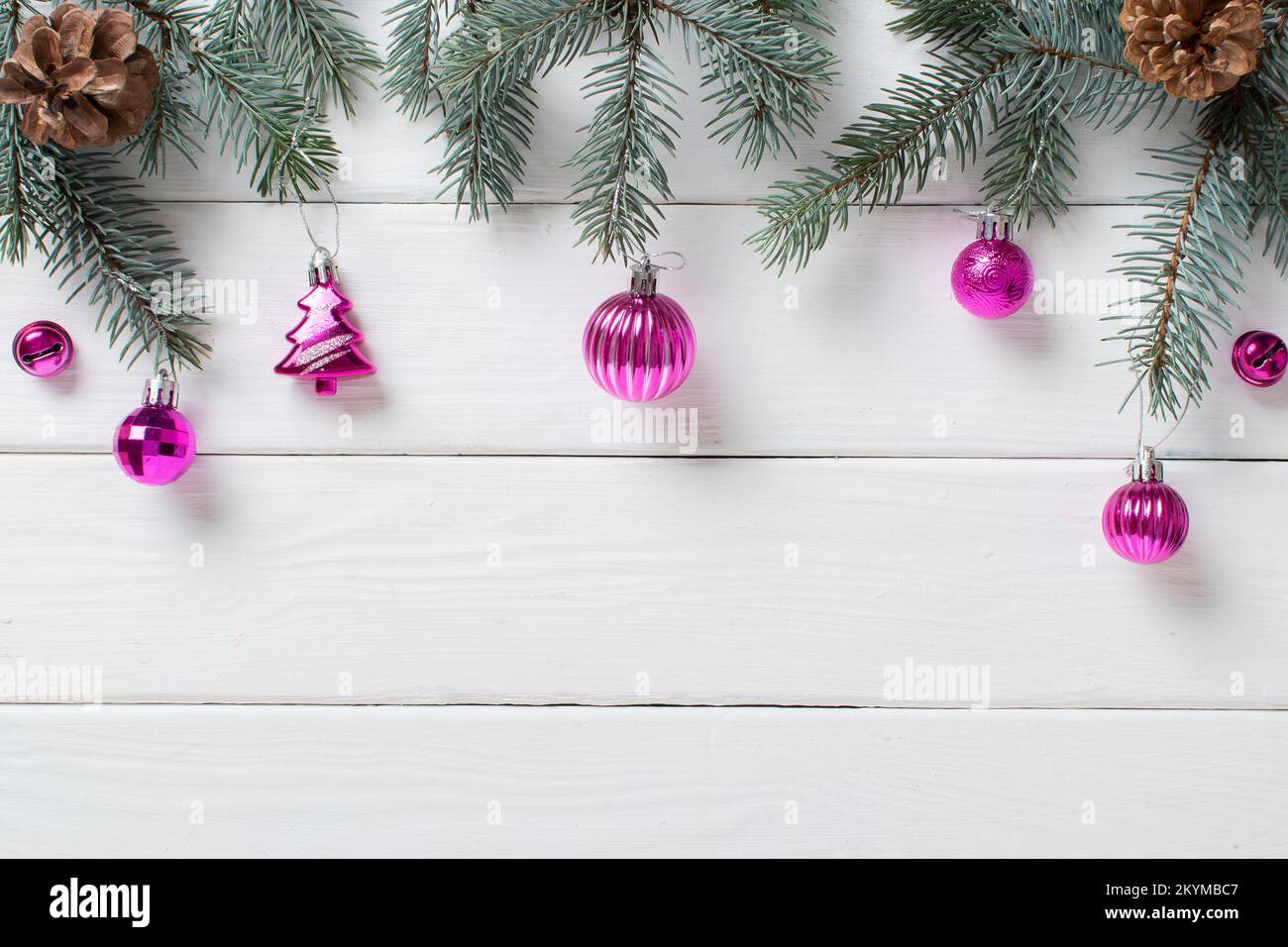 Branches de sapin et décorations de Noël roses sur fond blanc en bois. Minimalisme de Noël. Espace pour la copie. Position plate, vue de dessus. Banque D'Images