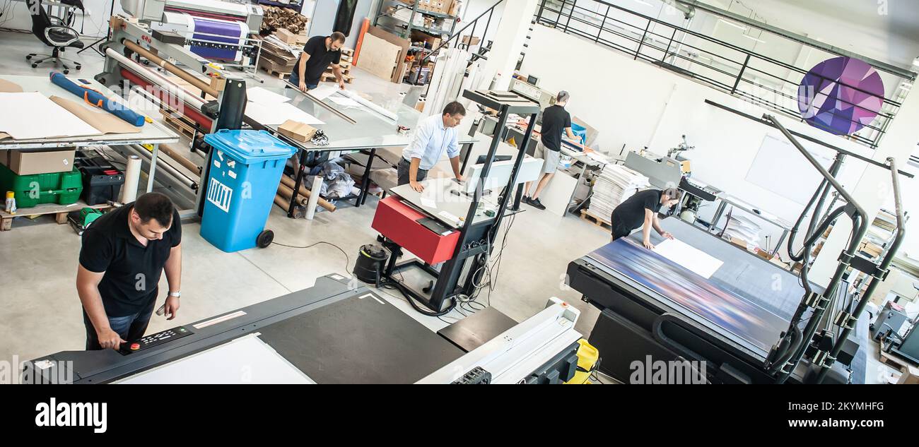 Dans une grande usine d'impression moderne, les opérateurs travaillent sur différents types de machines pour le matériel imprimé Banque D'Images