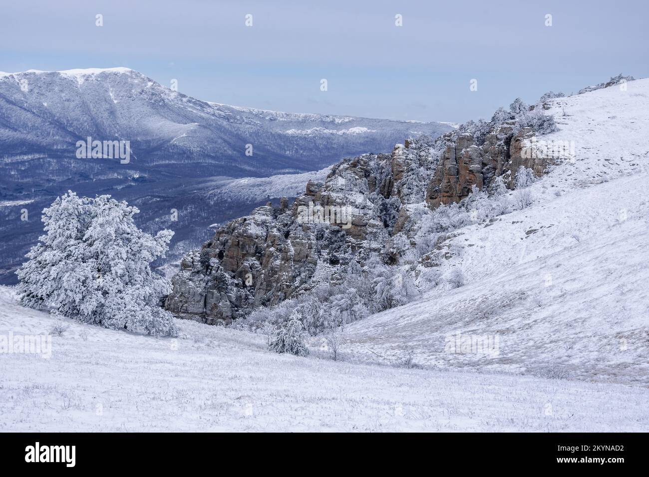 Rochers sur le sud de la montagne Demerdzhi dans la neige après blizzard au début du printemps. Et vue sur Chatyr-Dag. Crimée Banque D'Images