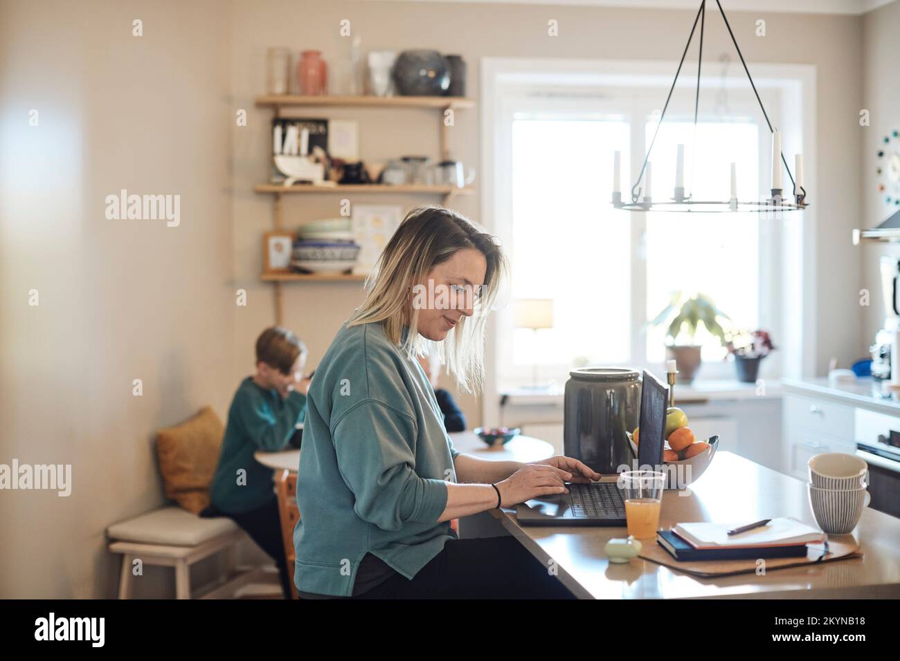 Femme souriante travaillant sur un ordinateur portable à la maison Banque D'Images