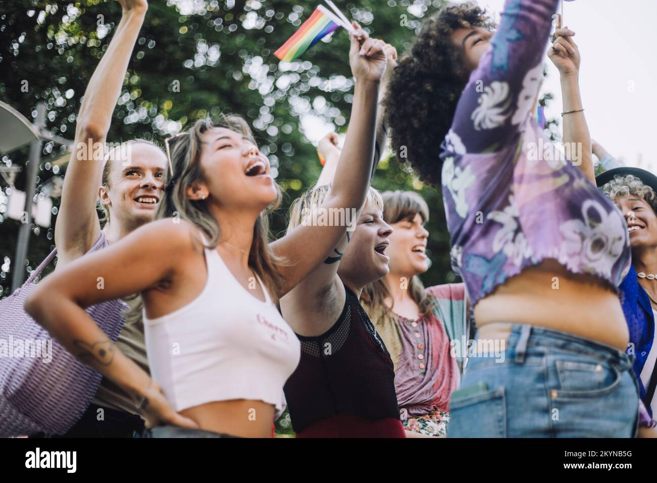 Des amis heureux avec des drapeaux arc-en-ciel criant pendant la parade des droits LGBTQIA Banque D'Images