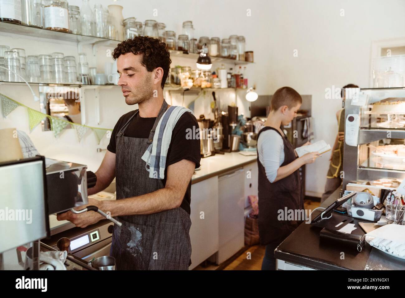 Un barista masculin prépare du café à l'aide d'une cafetière dans un café Banque D'Images