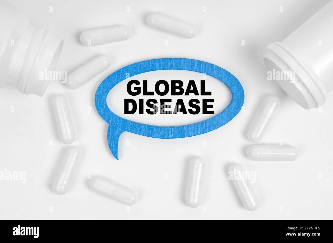Concept de médecine. Sur la table il y a des pilules et une plaque bleue à l'intérieur de laquelle l'inscription - MALADIE GLOBALE Banque D'Images