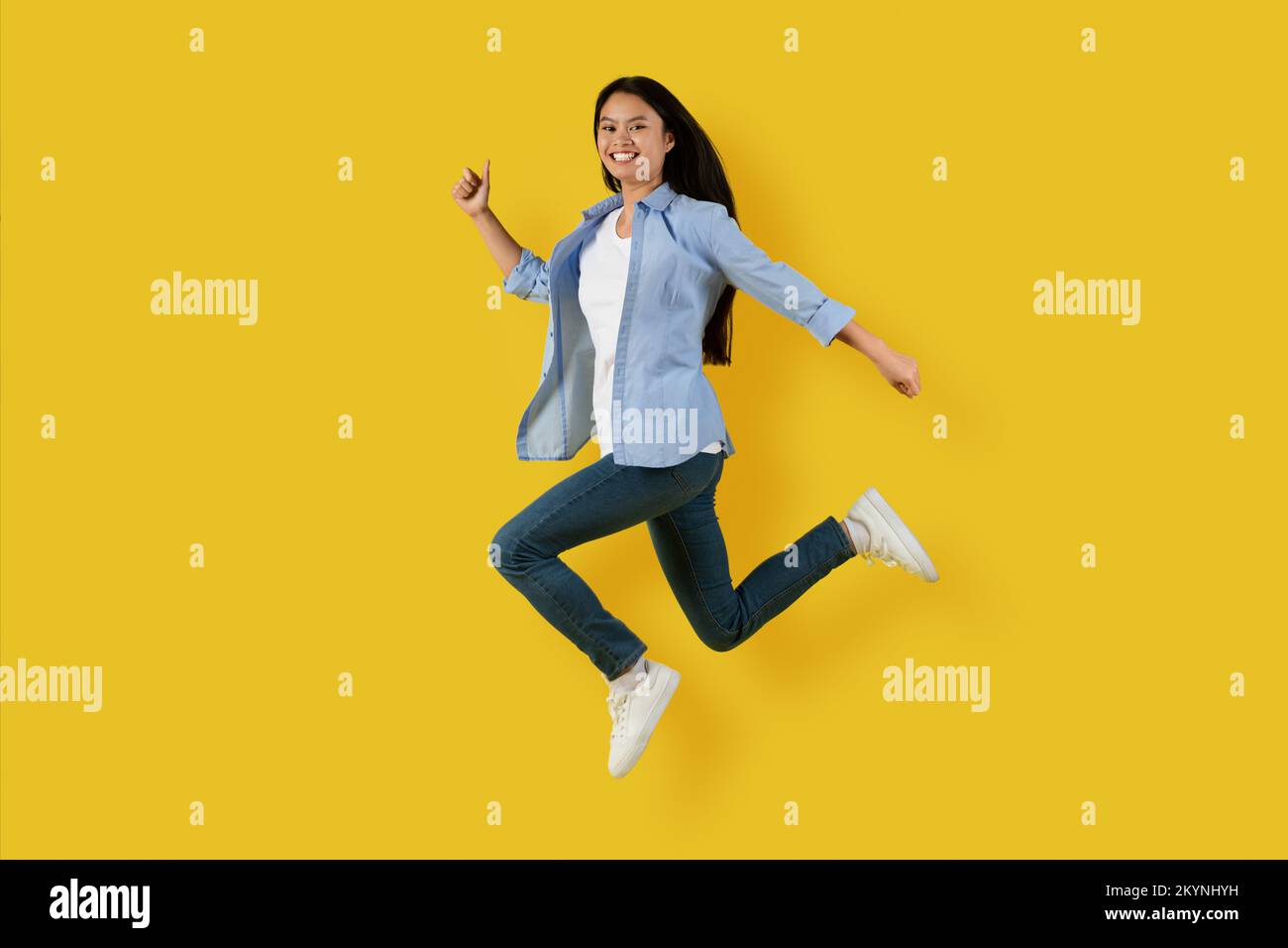 Heureux heureux mignon jeune femme coréenne étudiant dans le saut et le gel dans l'air profiter de la liberté, a l'amusement seul Banque D'Images