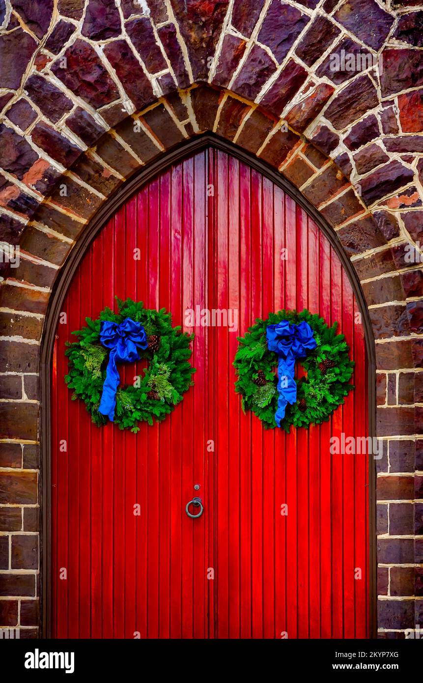Des couronnes de Noël sont accrochées aux portes rouges de l'église épiscopale All Saints, rue Government, 30 novembre 2022, à Mobile, Alabama. Banque D'Images