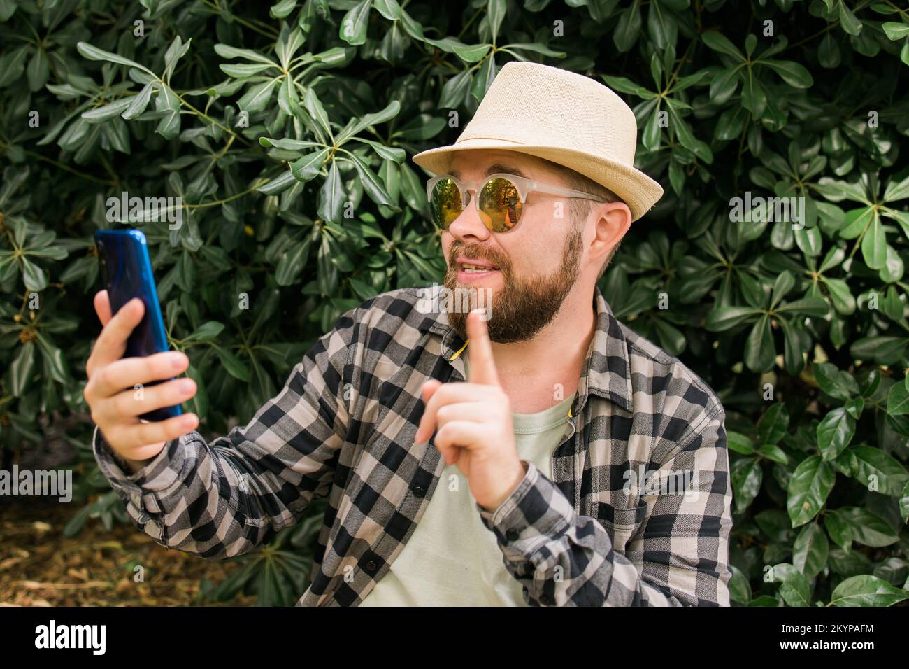 Homme barbu effectuant des appels vidéo sur smartphone extérieur - concept de connexion vidéo et de technologies Banque D'Images