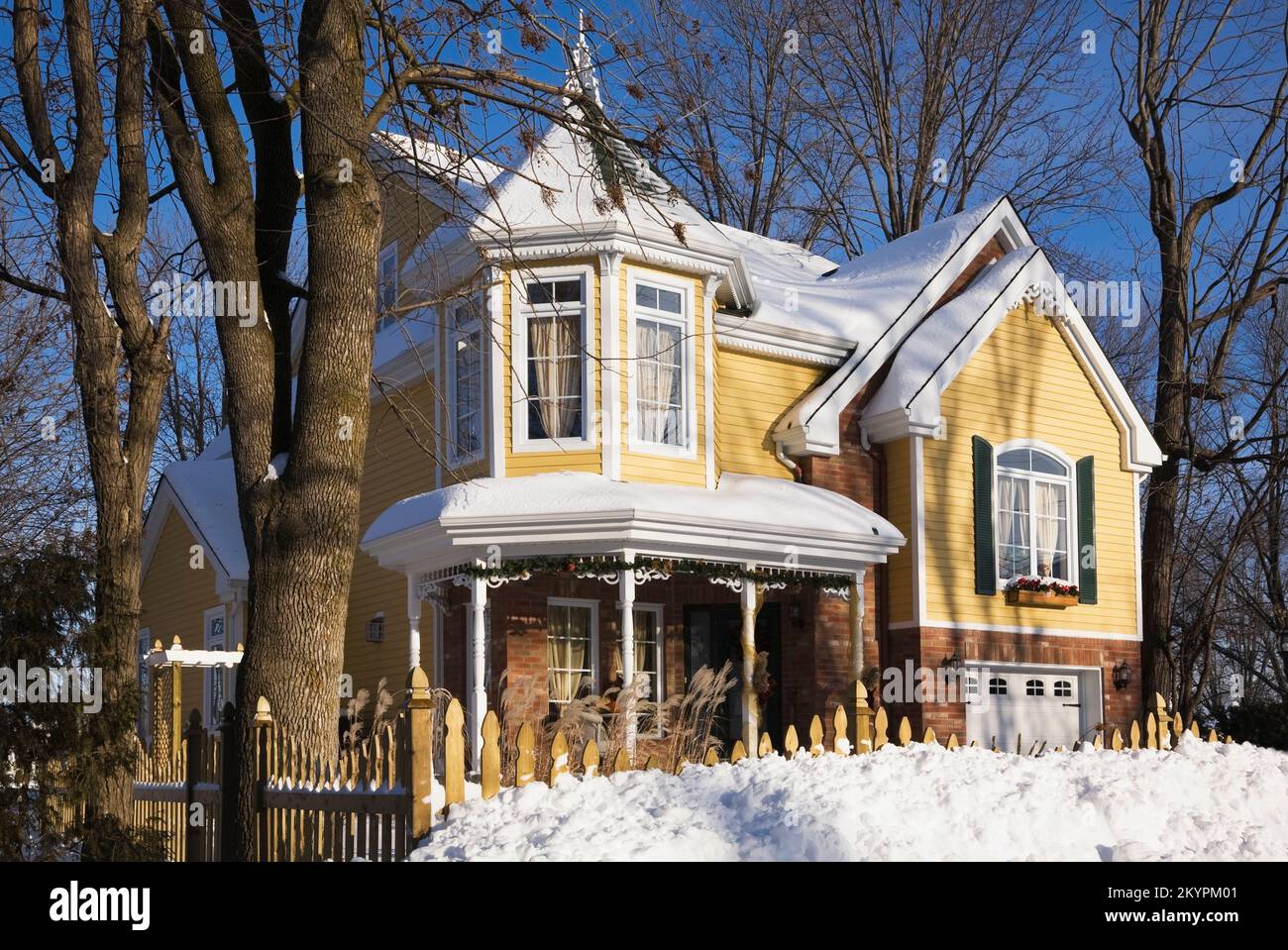 Briques nuancées rouges et jaunes avec bordure blanche et verte deux étagés style victorien maison en hiver. Banque D'Images