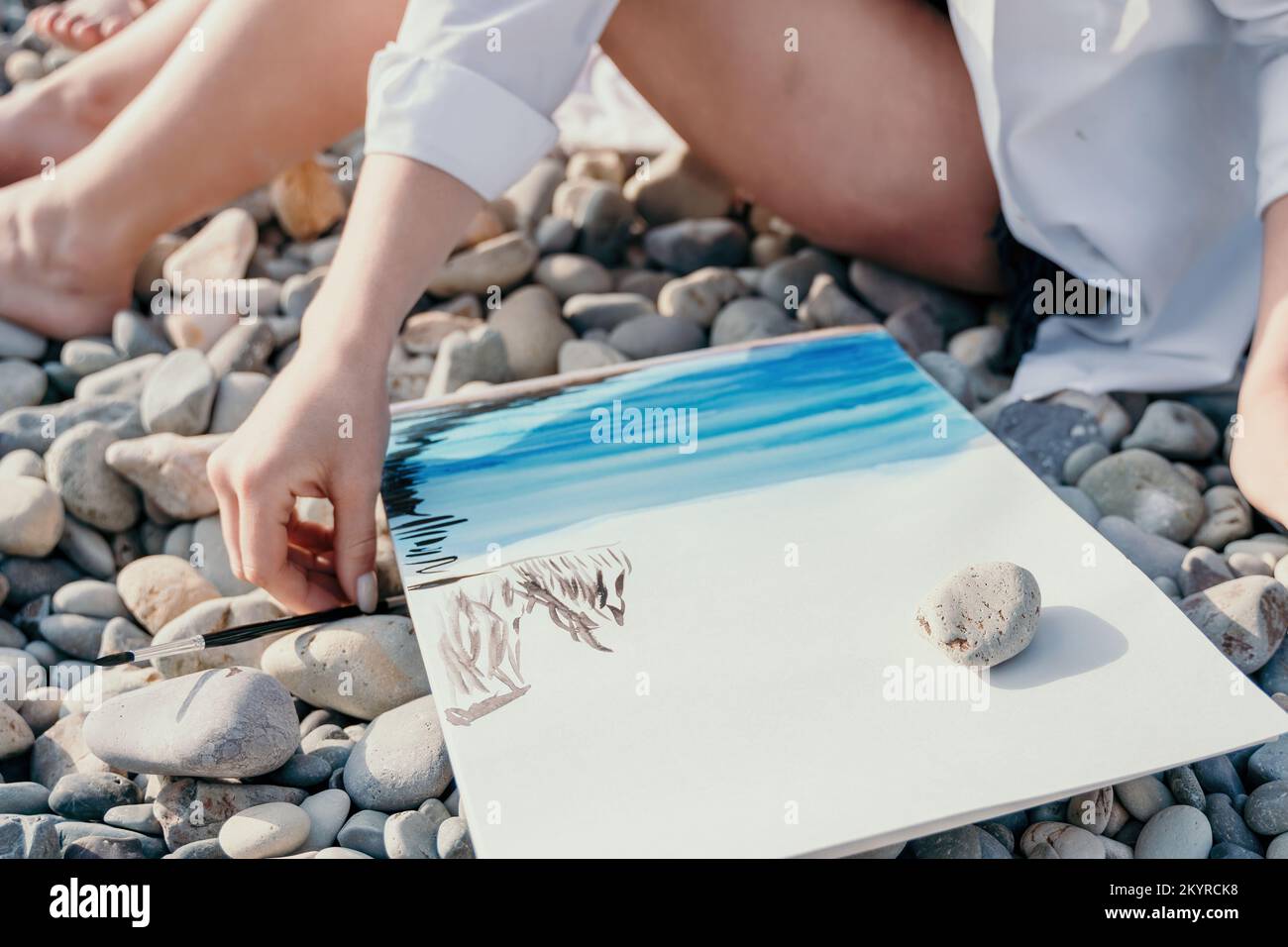 Mains de femme méconnaissable tenant sa propre plage de mer décor aquarelle peinture. Peintre amateur. Artiste féminine créative dessinant la photo sur le Banque D'Images
