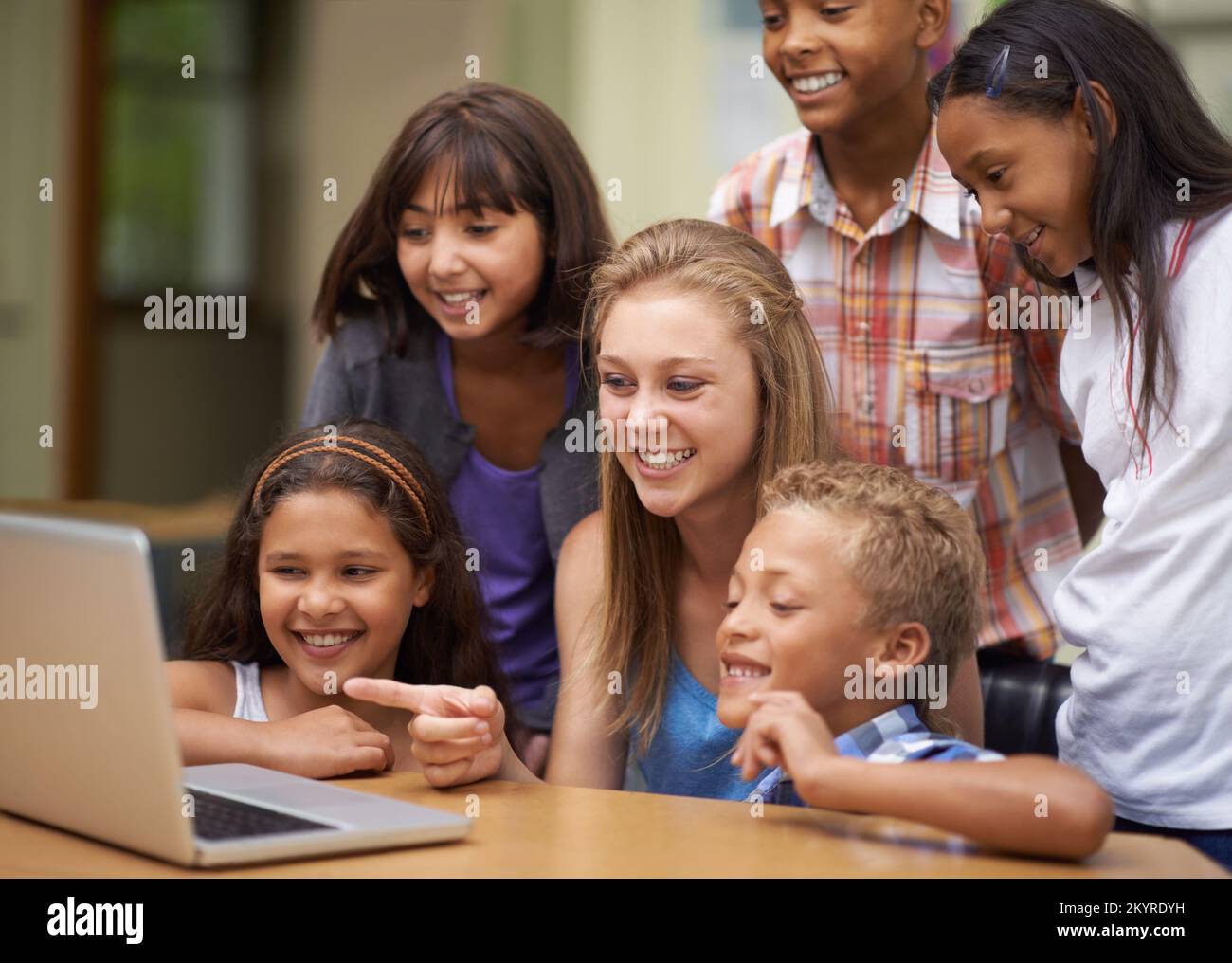 En savoir plus sur les ordinateurs. Un groupe d'élèves travaillant sur un ordinateur portable en classe. Banque D'Images