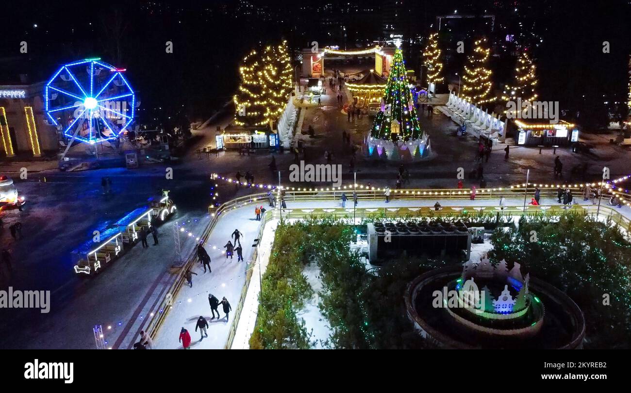 Beaucoup de personnes patinent sur la patinoire en plein air décoré illuminations de Noël du nouvel an, décorations, guirlandes lumineuses pendant la nuit d'hiver. Fête de Noël du nouvel an. Vue aérienne Banque D'Images