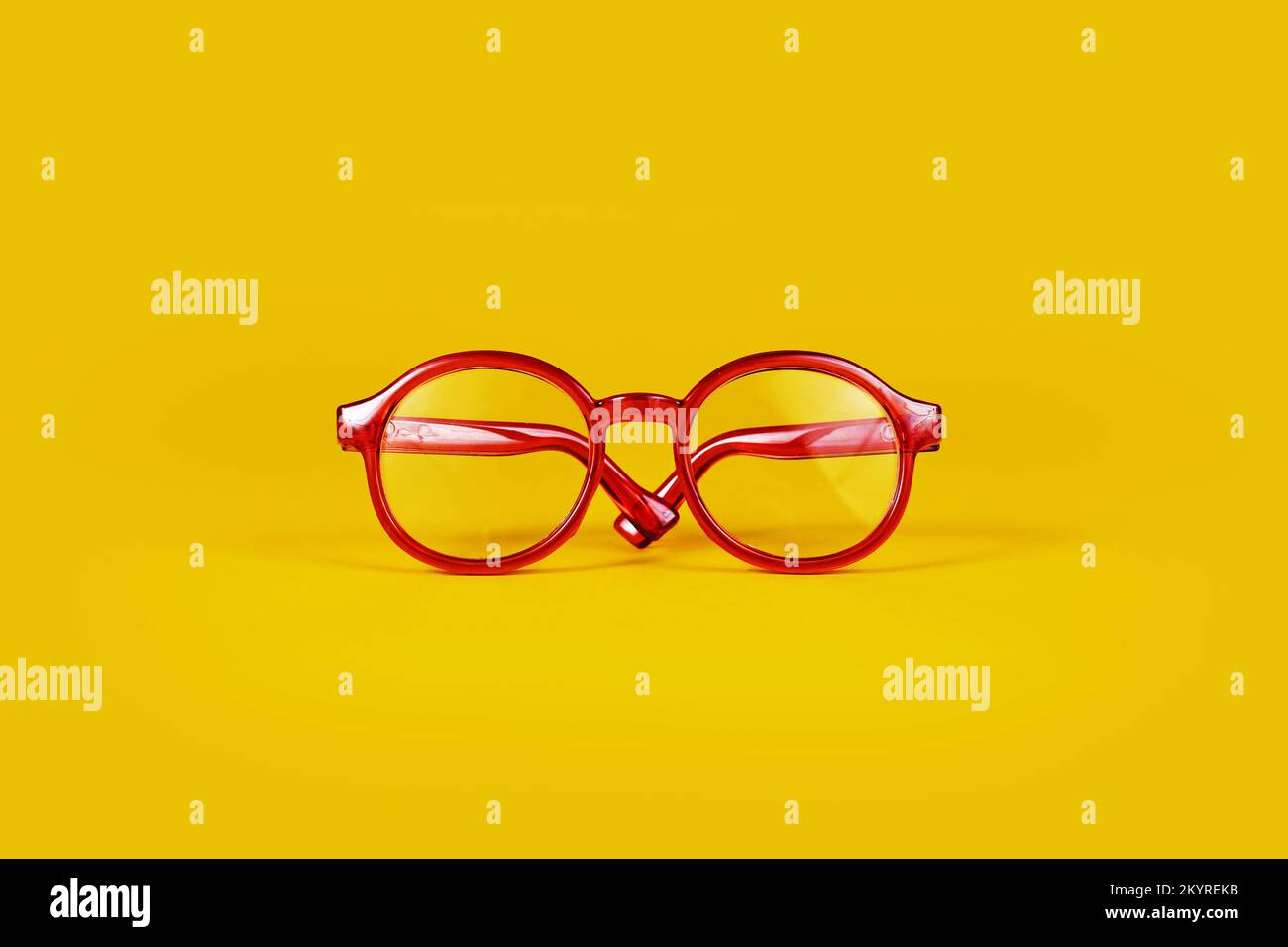 Petites lunettes rouges rondes sur fond jaune Banque D'Images