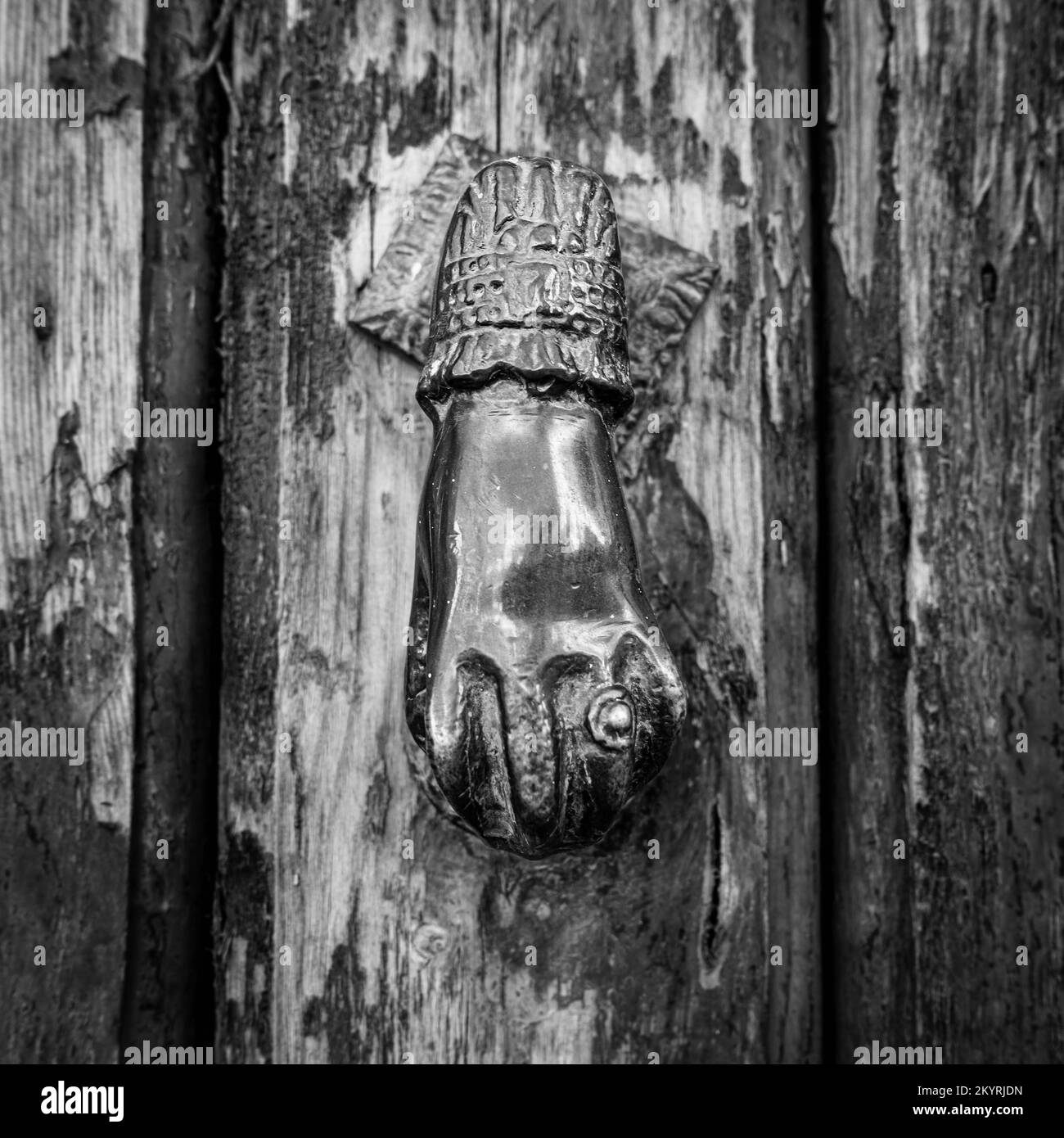 Bouton de porte main humaine en forme de noir et blanc sur un fond texturé en bois d'une porte Banque D'Images