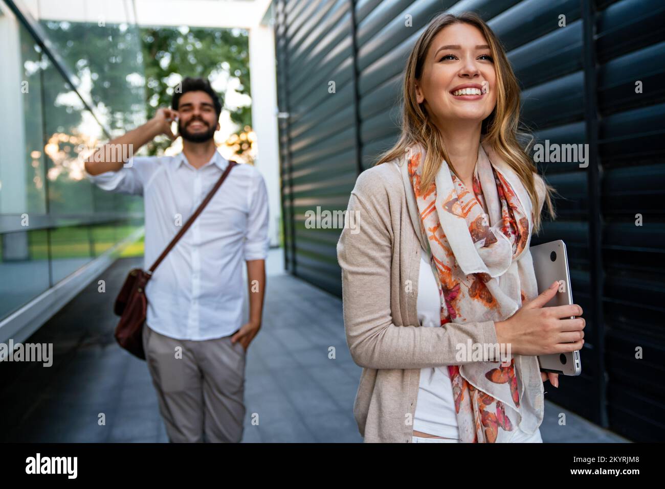 Portrait de jeunes gens d'affaires joyeux et heureux qui parlent, qui marchent à l'extérieur Banque D'Images