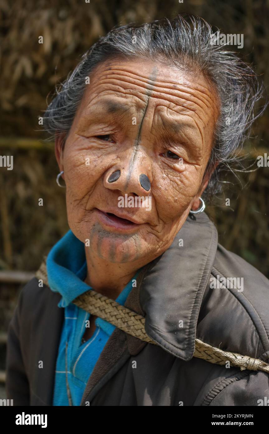 Ziro, Arunachal Pradesh, Inde - 03 04 2014 : Portrait de la vieille femme tribale d'Apatani avec tatouages faciaux traditionnels et prises de nez marchant dans le village Banque D'Images