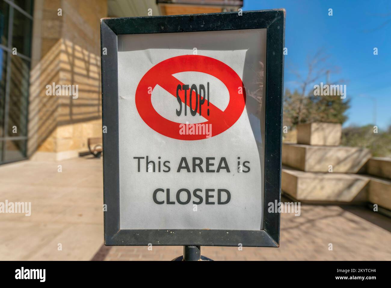 Austin, Texas - signalisation encadrée avec arrêt cette zone est fermée. Gros plan d'un panneau avec un fond de bâtiment flou et le ciel à l'arrière-plan. Banque D'Images