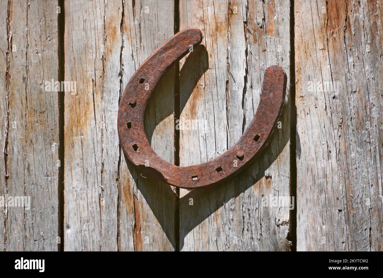 Vieux fer à cheval rouillé sur un mur en bois. Symbole de chance. Banque D'Images