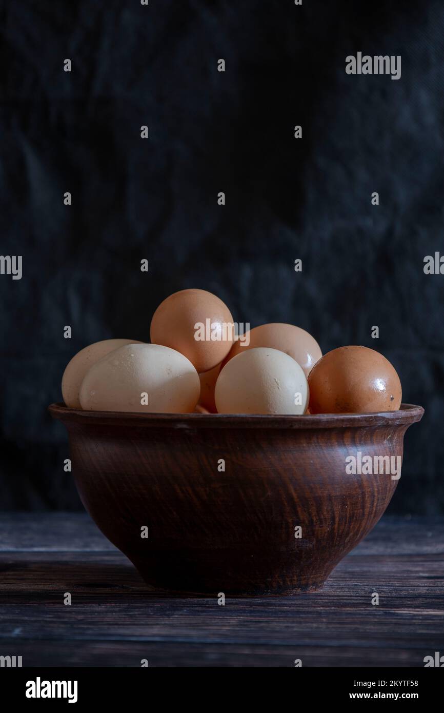 Oeufs de poulet dans une assiette en argile sur la table. Banque D'Images
