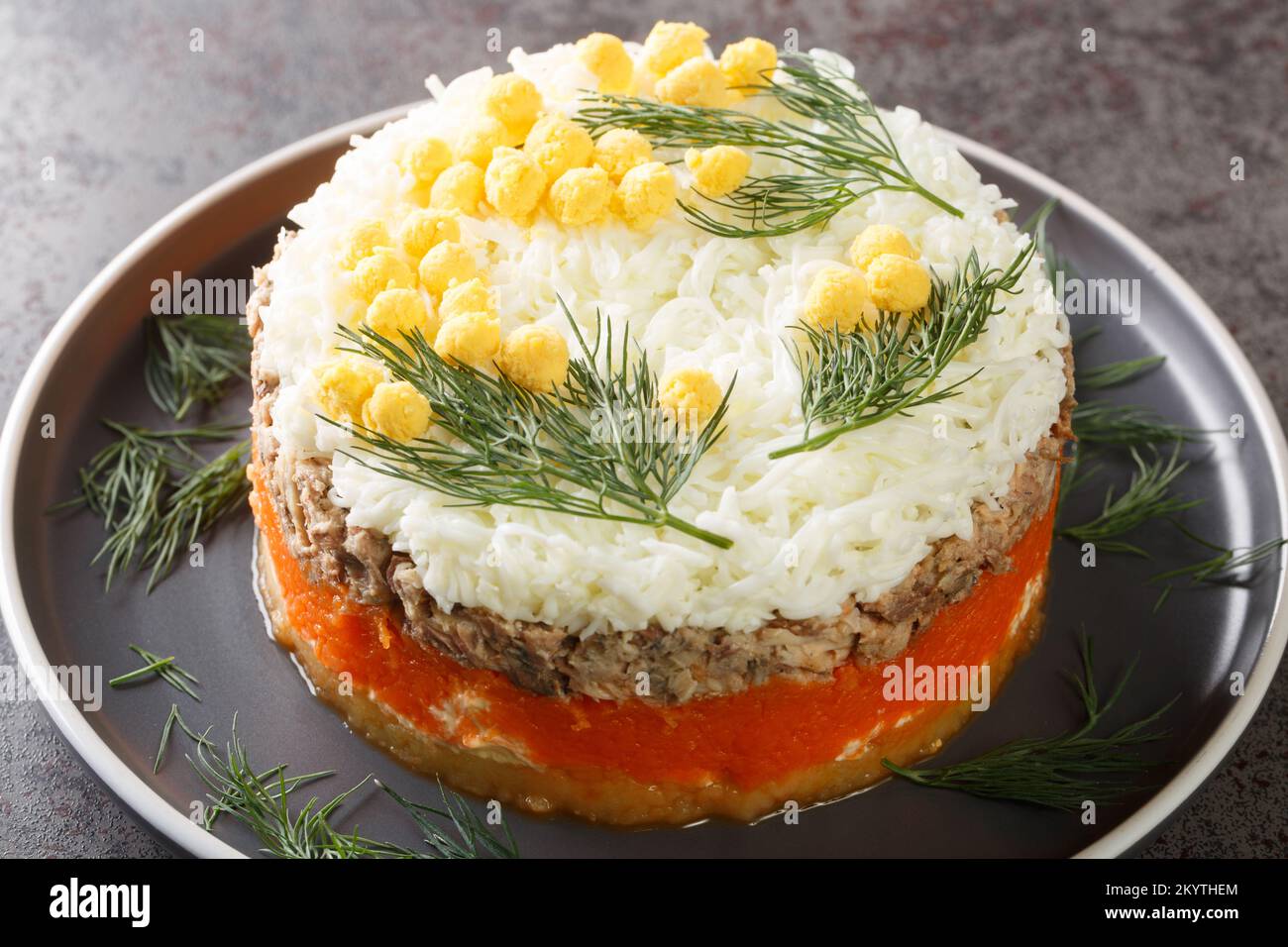 Salade mimosa avec saurie en conserve, pommes de terre, fromage, carottes et œufs à proximité sur l'assiette de la table. Horizontale Banque D'Images