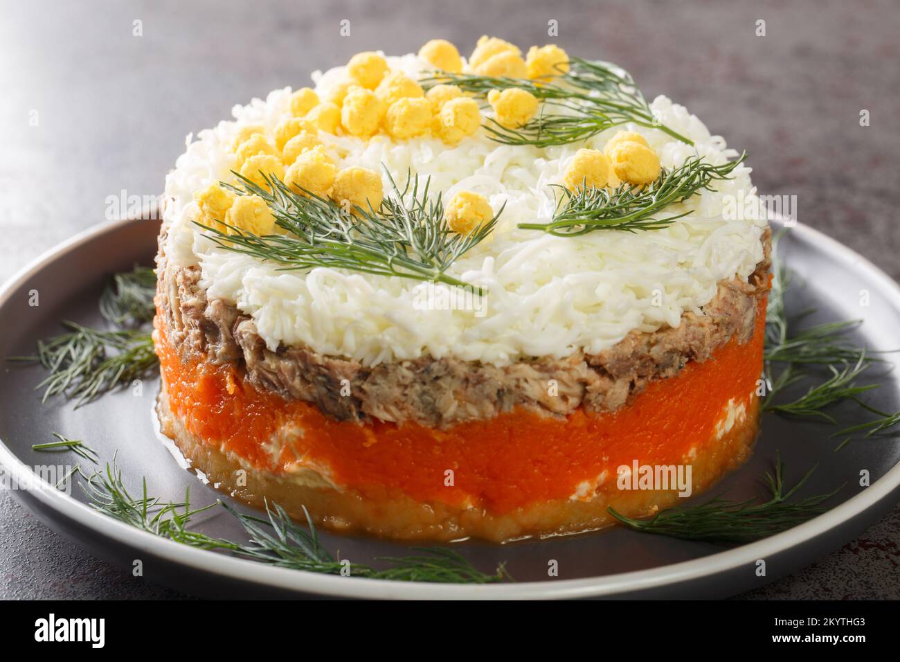 Salade russe de fête Mimosa avec saury en conserve, pommes de terre, fromage, carottes et œufs à proximité sur l'assiette de la table. Horizontale Banque D'Images