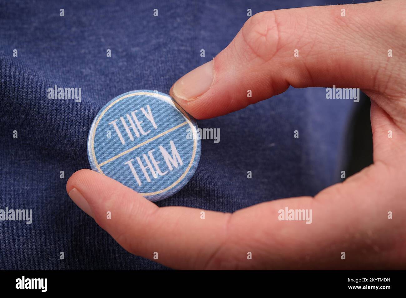 Une personne qui leur montre leur pronoms en portant un badge. Banque D'Images