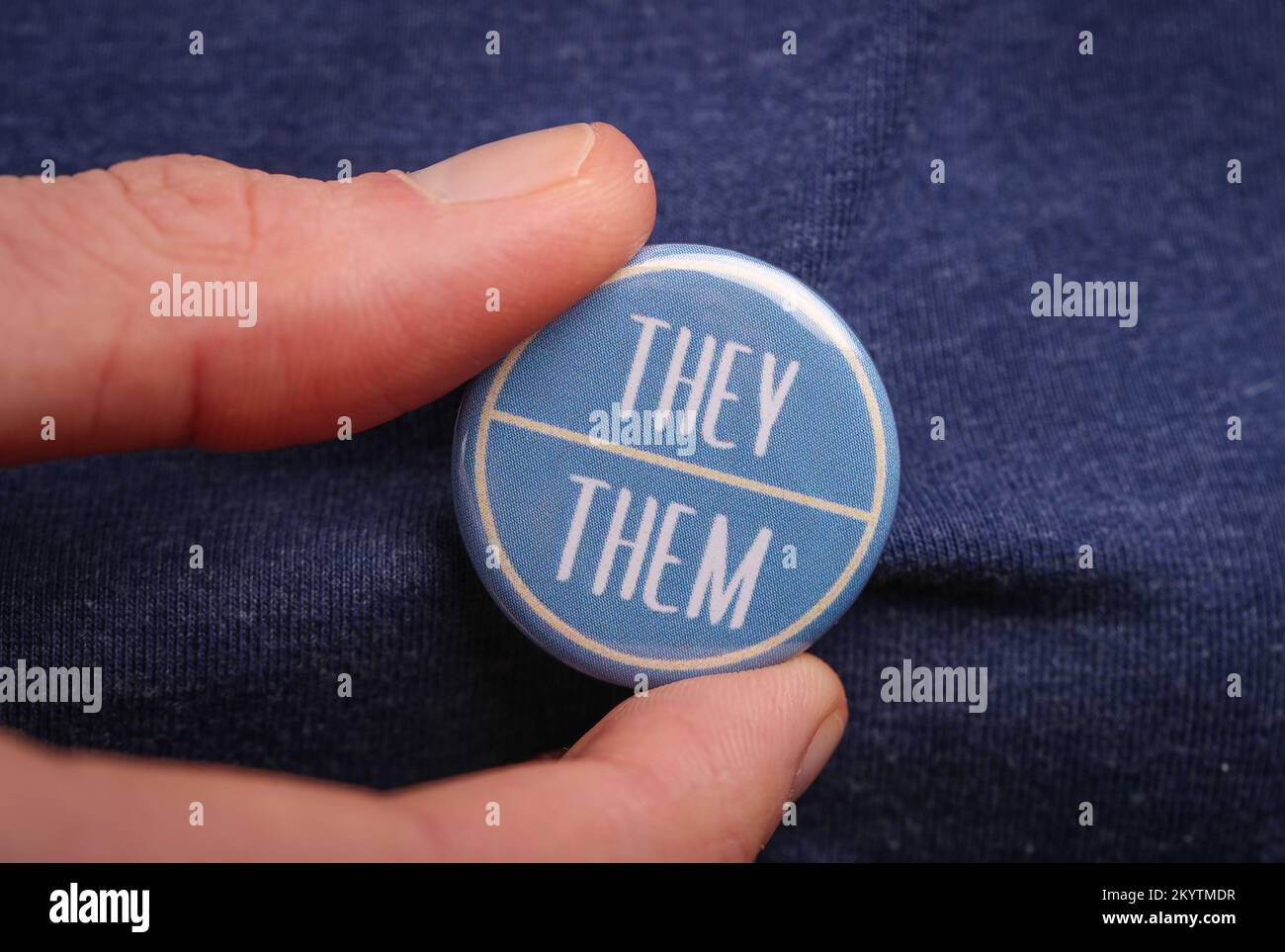 Une personne qui leur montre leur pronoms en portant un badge. Banque D'Images