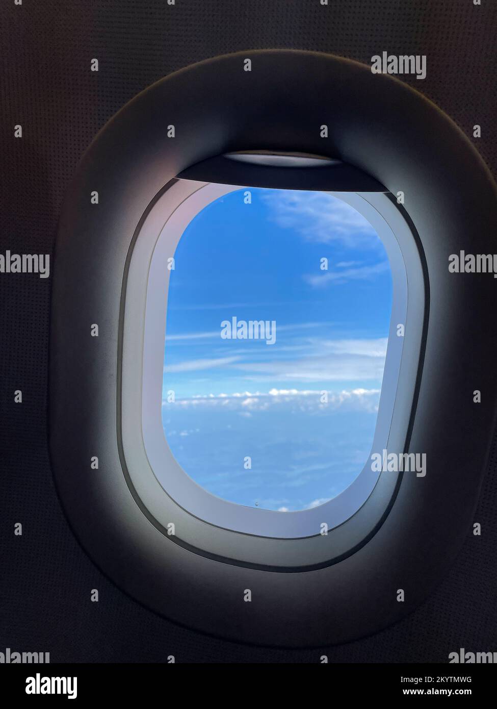 Vue à travers la fenêtre de l'avion sur le beau ciel bleu et des nuages blancs moelleux ensoleillées. Photographie sur smartphone Banque D'Images