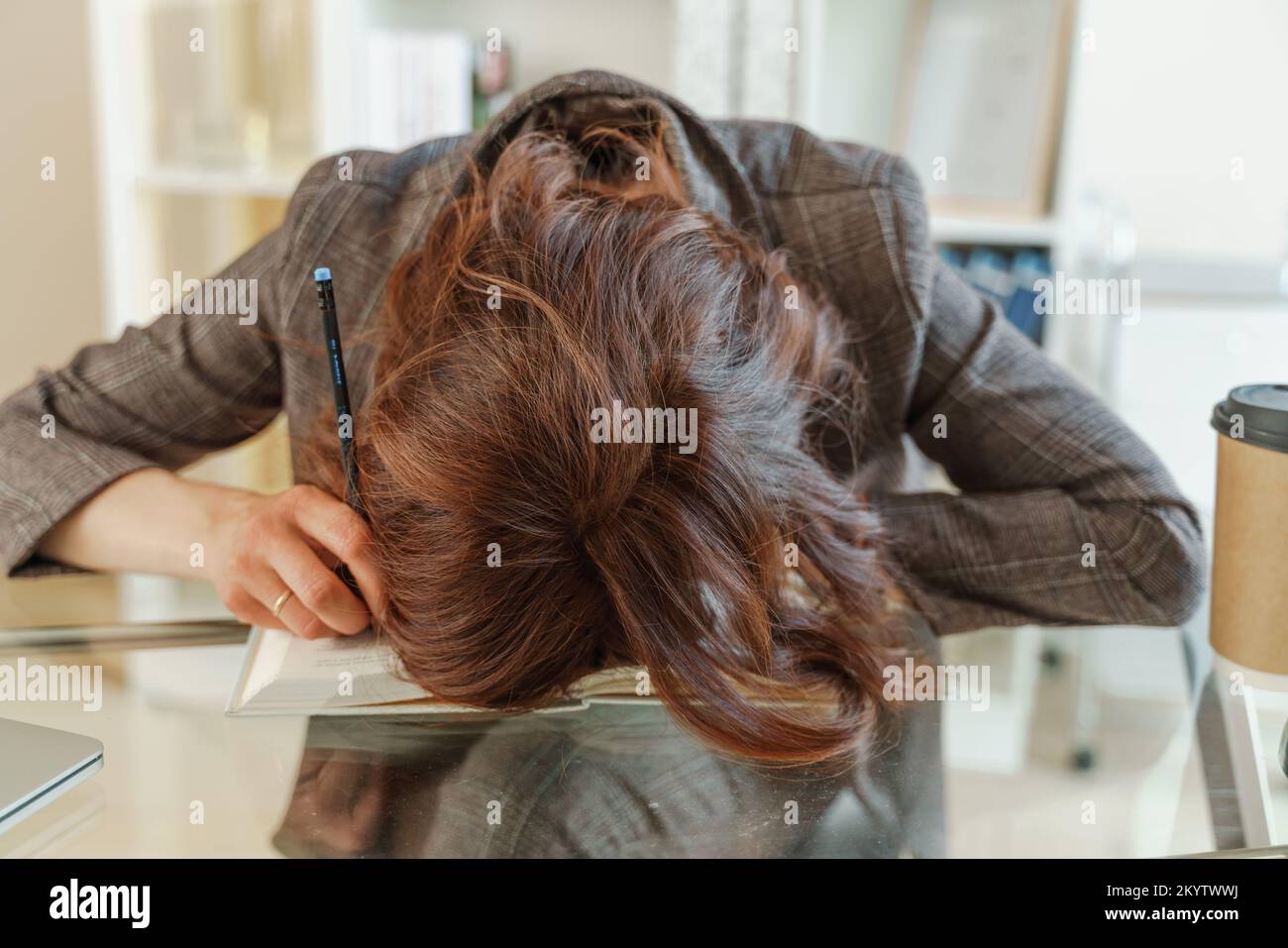 La femme est fatiguée. Une jeune femme fatiguée a mis sa tête sur la table, une travailleuse fatiguée ou une étudiante s'étant épuisée sur la table à la maison Banque D'Images