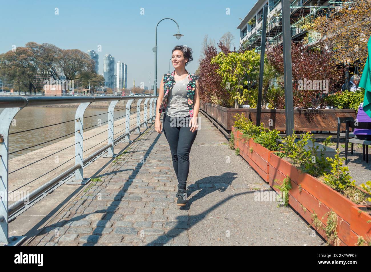 Vue de face femme adulte caucasienne, sourire va heureux de marcher dans la rue, à Puerto Madero Buenos Aires, argentine. Banque D'Images