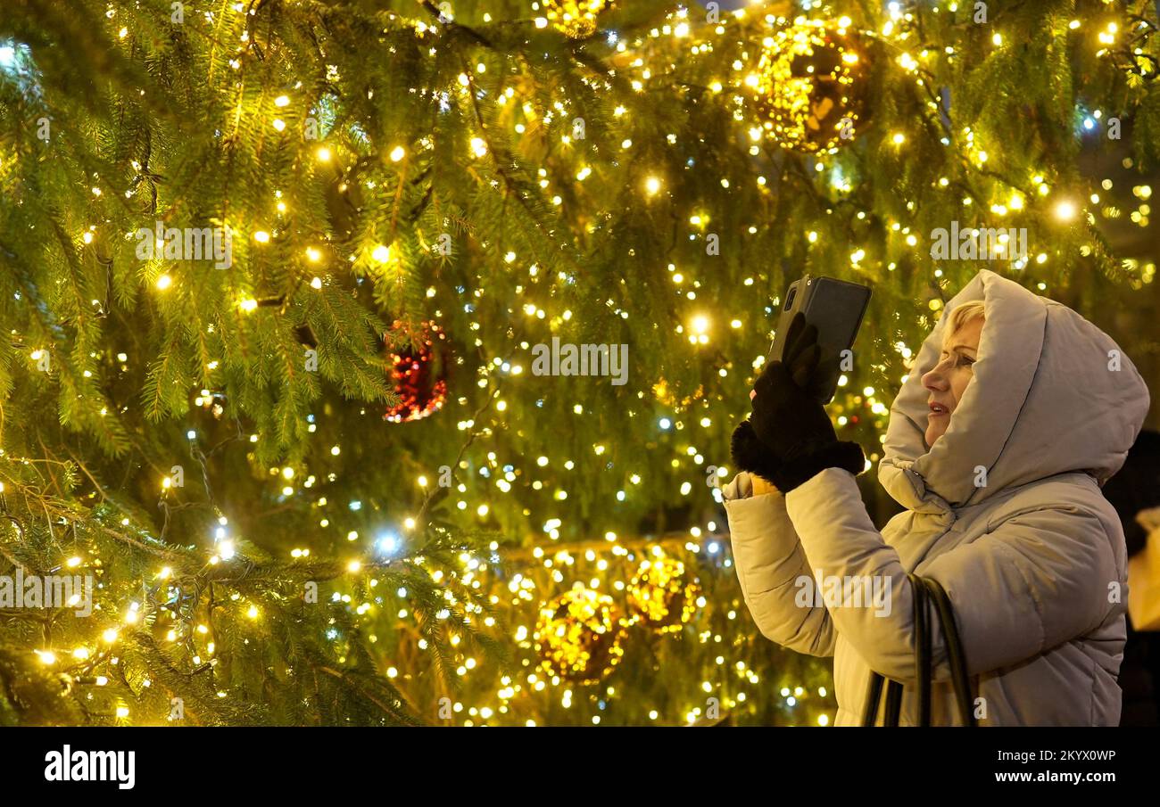 Une femme prend une photo de l'arbre de Noël sur le marché de Noël à Riga, en Lettonie 2 décembre 2022. REUTERS/Ints Kalnins Banque D'Images