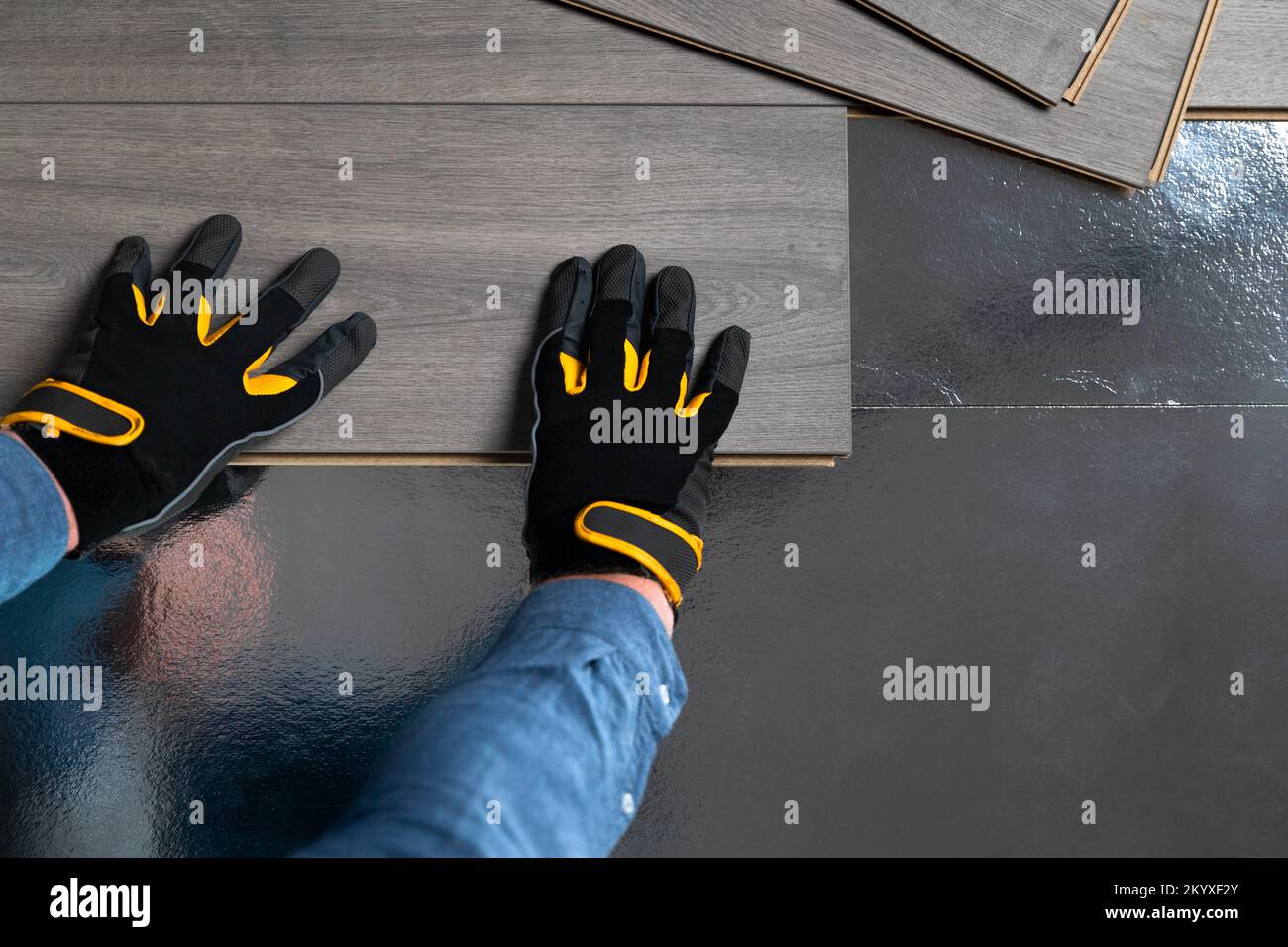 Installation du plancher flottant, sous-couche de mise à la main pour le stratifié. Concept d'amélioration de la maison. Banque D'Images