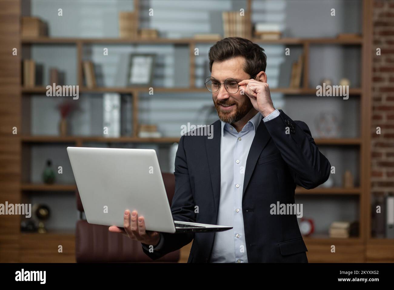 Homme d'affaires mature avocat travaille dans le serveur de bureau utilise ordinateur portable, patron senior en lunettes et costume d'affaires homme souriant dans le bureau. Banque D'Images