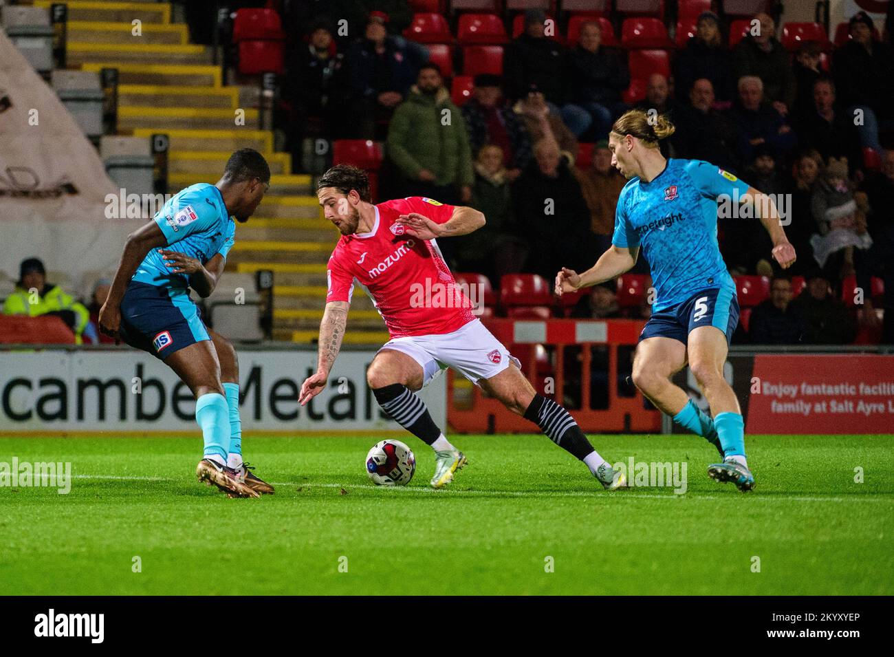 Cole Stockton de Morecambe FC sous la pression de Cheick Diabaté et Alex Hartridge de Exeter City FC lors du match Sky Bet League 1 entre Morecambe et Exeter City au stade Mazuma, Morecambe, le vendredi 2nd décembre 2022. (Credit: Ian Charles | MI News) Credit: MI News & Sport /Alay Live News Banque D'Images