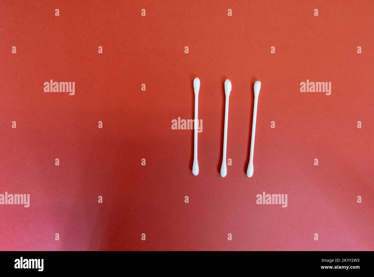 numéro trois (3) en chiffres romains avec des bourgeons de coton blanc propre isolés sur un fond rouge foncé Banque D'Images