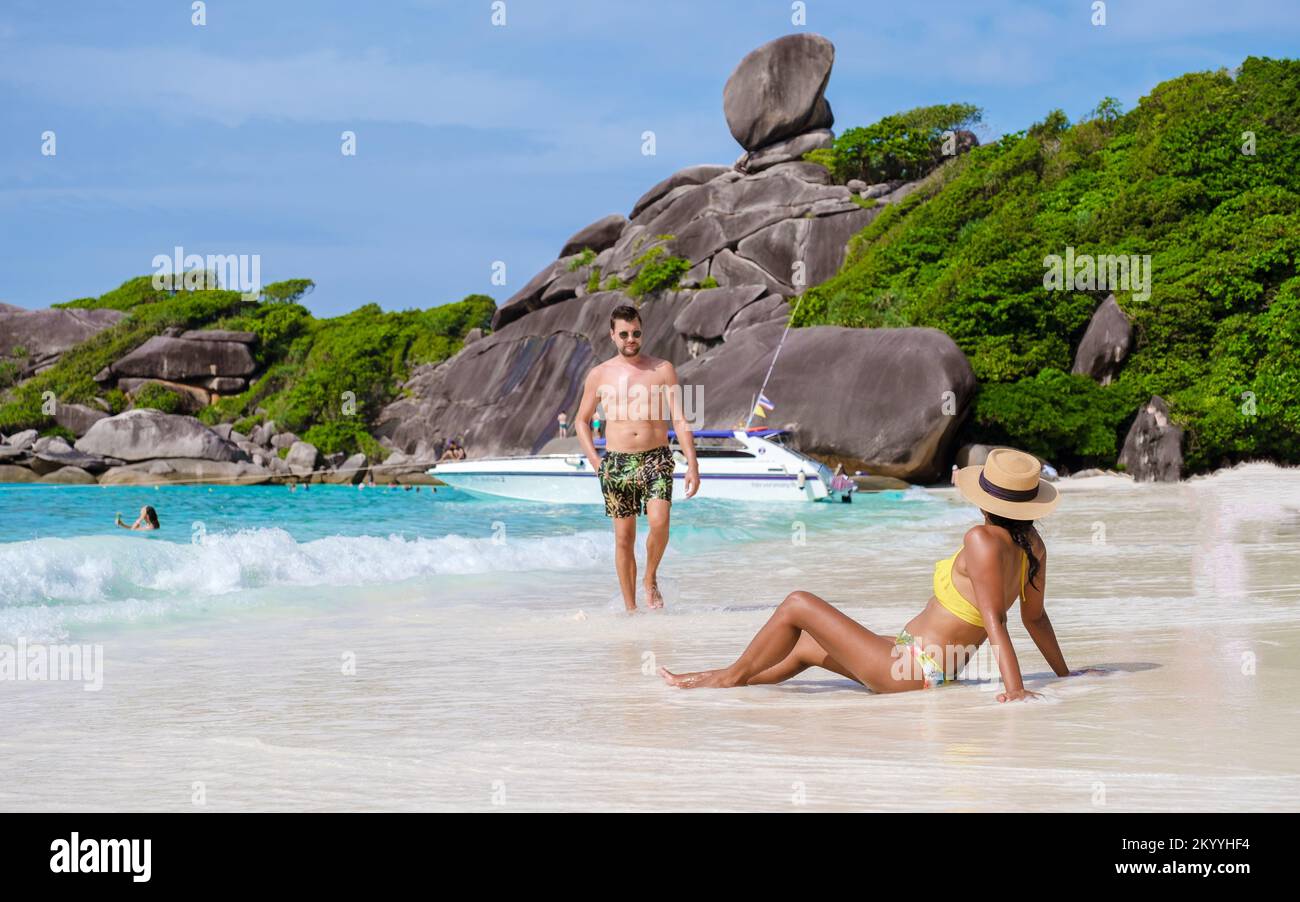 Les hommes caucasiens et les femmes noires se détendent sur une plage tropicale en Thaïlande, dans les îles Similan. Banque D'Images