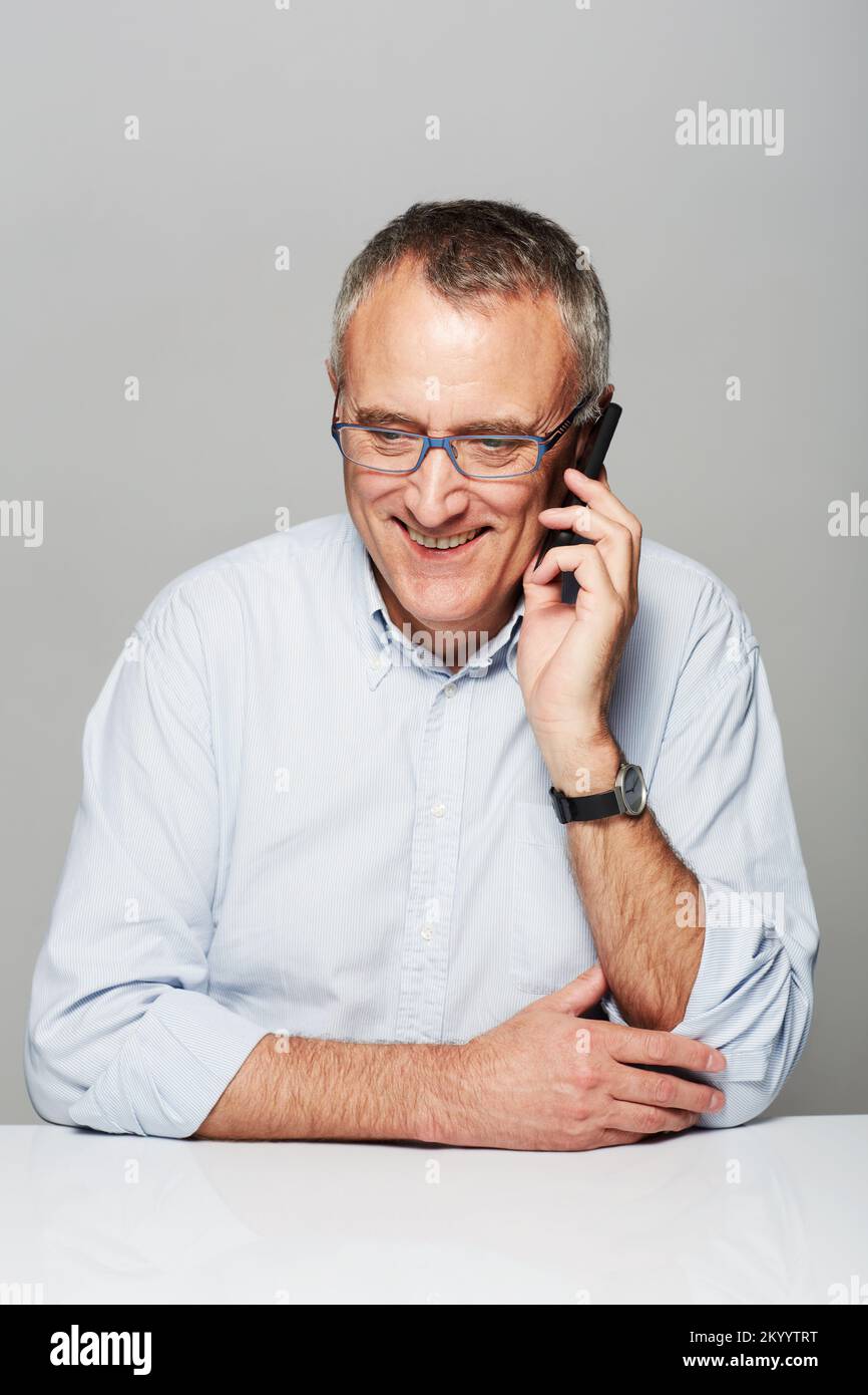 Super pour entendre à nouveau votre voix. Photo studio d'un homme plus âgé parlant sur un téléphone portable. Banque D'Images