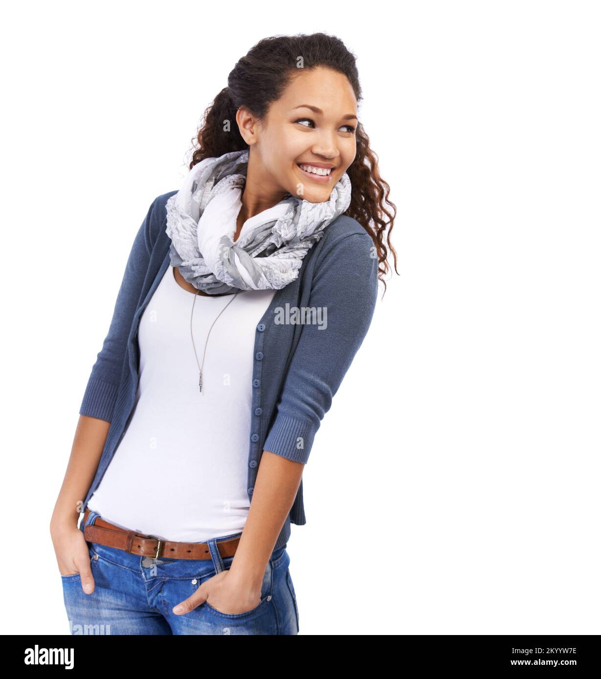 C'est ce qu'il y a de plus. Une belle jeune femme debout avec les mains dans ses poches et souriant sur un fond blanc. Banque D'Images