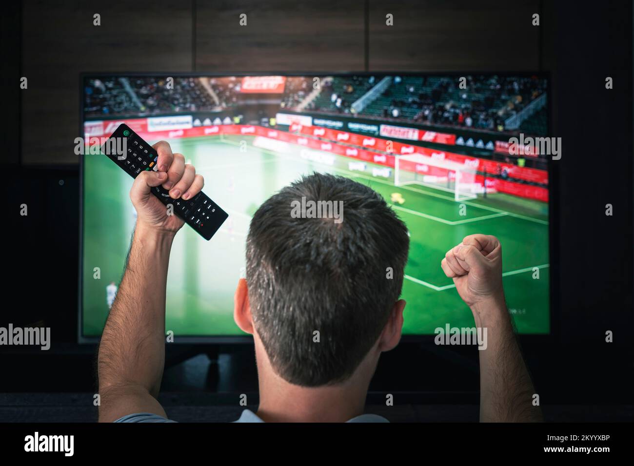 Les loisirs, la technologie, le sport, le divertissement et les gens concept - homme avec télécommande regarder le football ou de soccer à la télévision à la maison. Soccer excité Banque D'Images