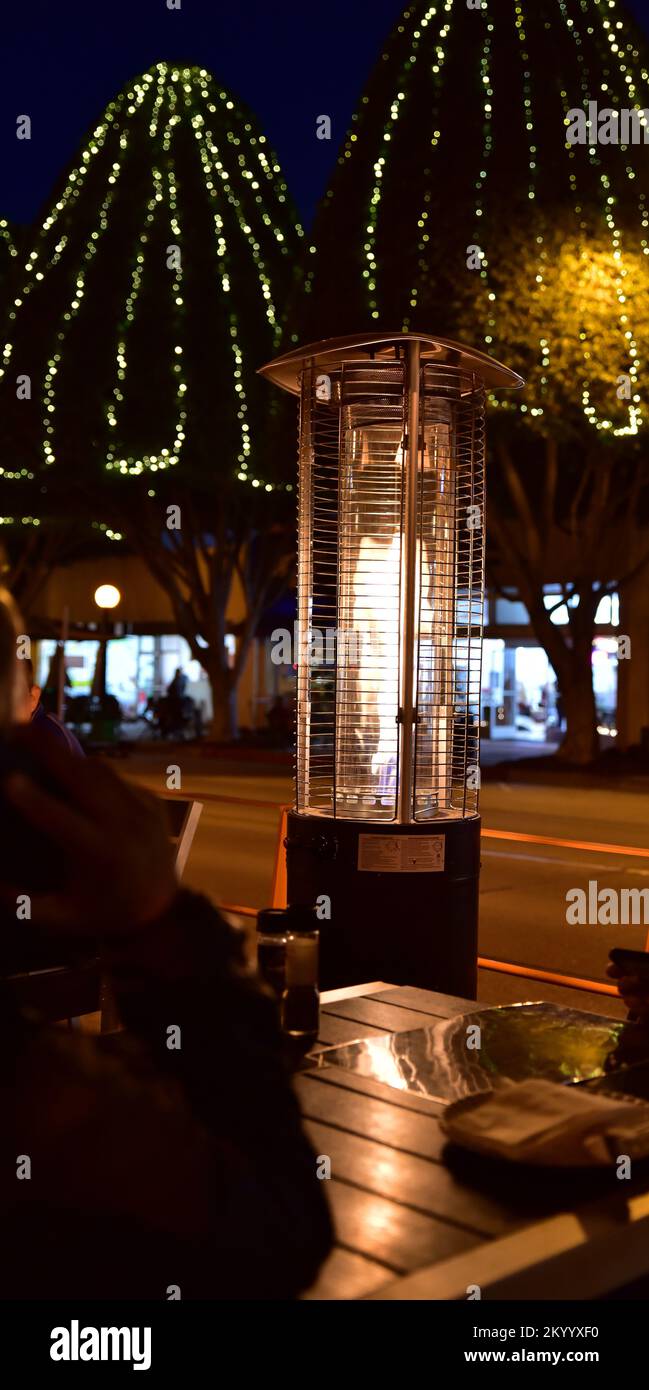 Grande table chauffante extérieure au propane en acier inoxydable, assise au-dessus d'une table de restaurant Banque D'Images