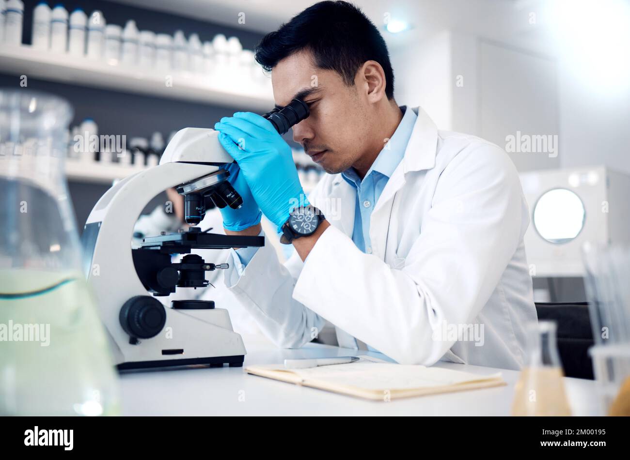 Microscope, homme asiatique en laboratoire pour les soins de santé, les méthodes scientifiques et l'innovation en recherche. Homme chercheur, chimiste et médecin Banque D'Images