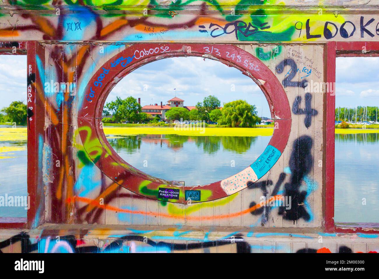 Le Detroit Yacht Club vu d'une passerelle piétonne graffitiée à travers un étang de Belle Isle à Detroit, Michigan, États-Unis. Banque D'Images
