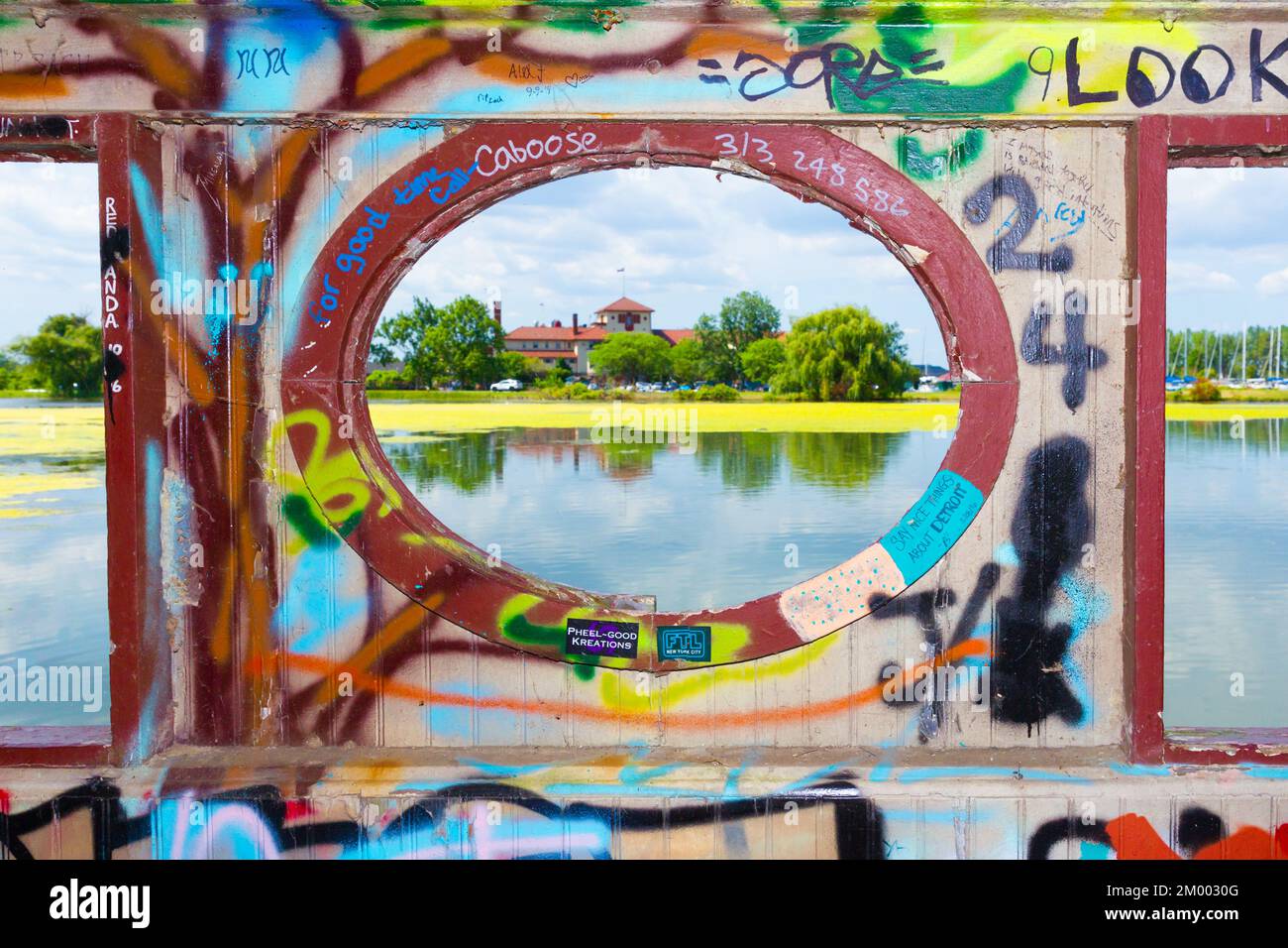 Le Detroit Yacht Club vu d'une passerelle piétonne graffitiée à travers un étang de Belle Isle à Detroit, Michigan, États-Unis. Banque D'Images