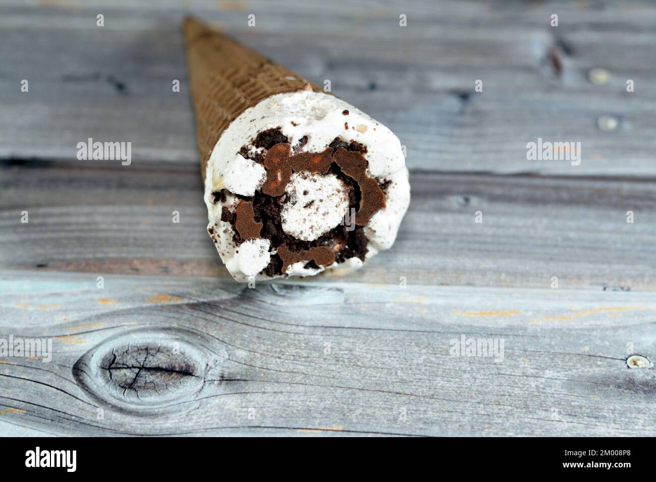 Cône de vanille à la crème glacée avec garniture de morceaux de copeaux de chocolat dans des cônes de cachets croustillants, foyer sélectif de la fusion de la crème glacée froide dans un bisc de cachets Banque D'Images
