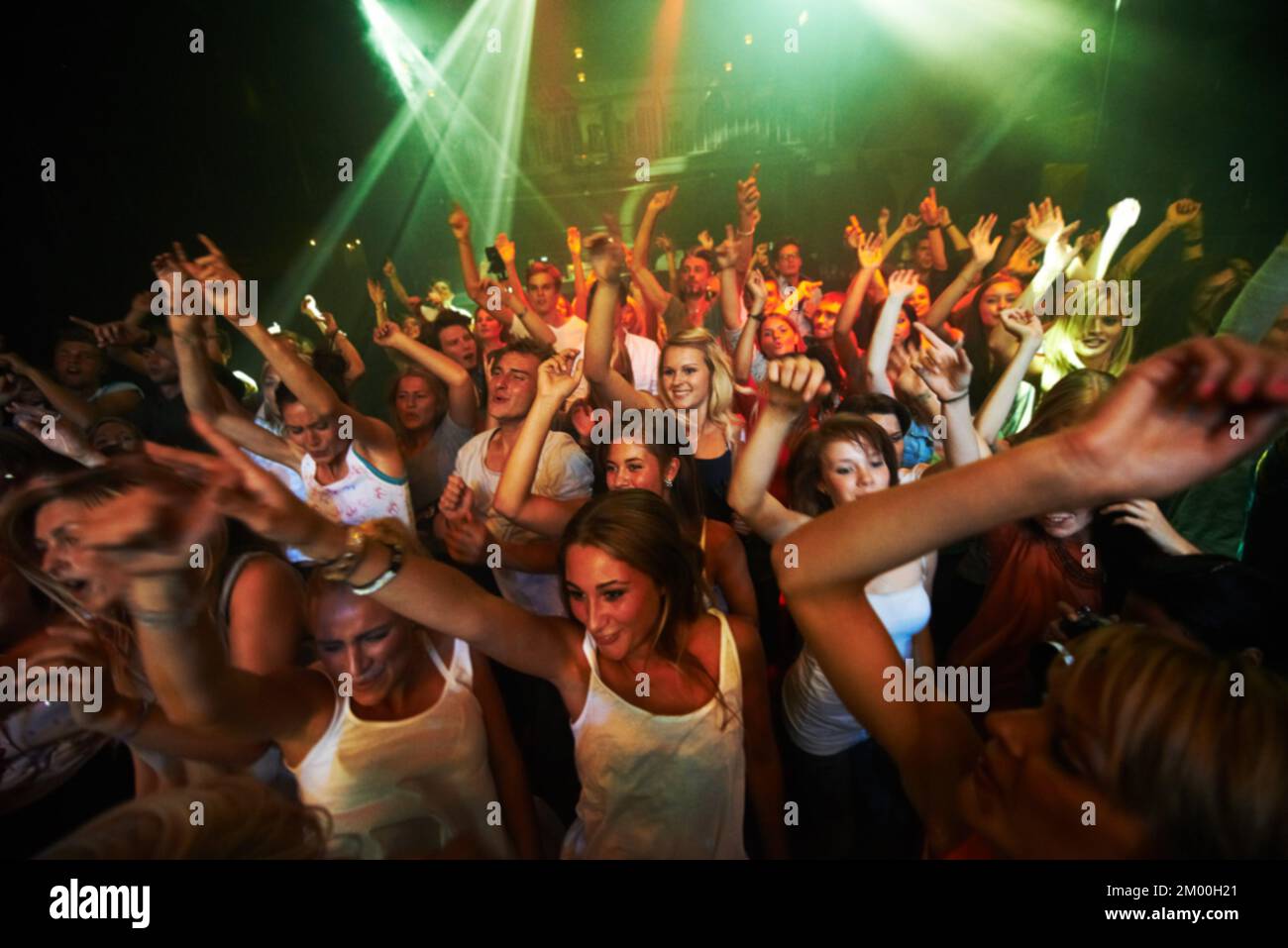 Fête, musique et danse avec la foule au concert pour le rock, le festival et la représentation de groupe en direct. La lumière, le laser et l'énergie avec le public à l'écoute de dj at Banque D'Images