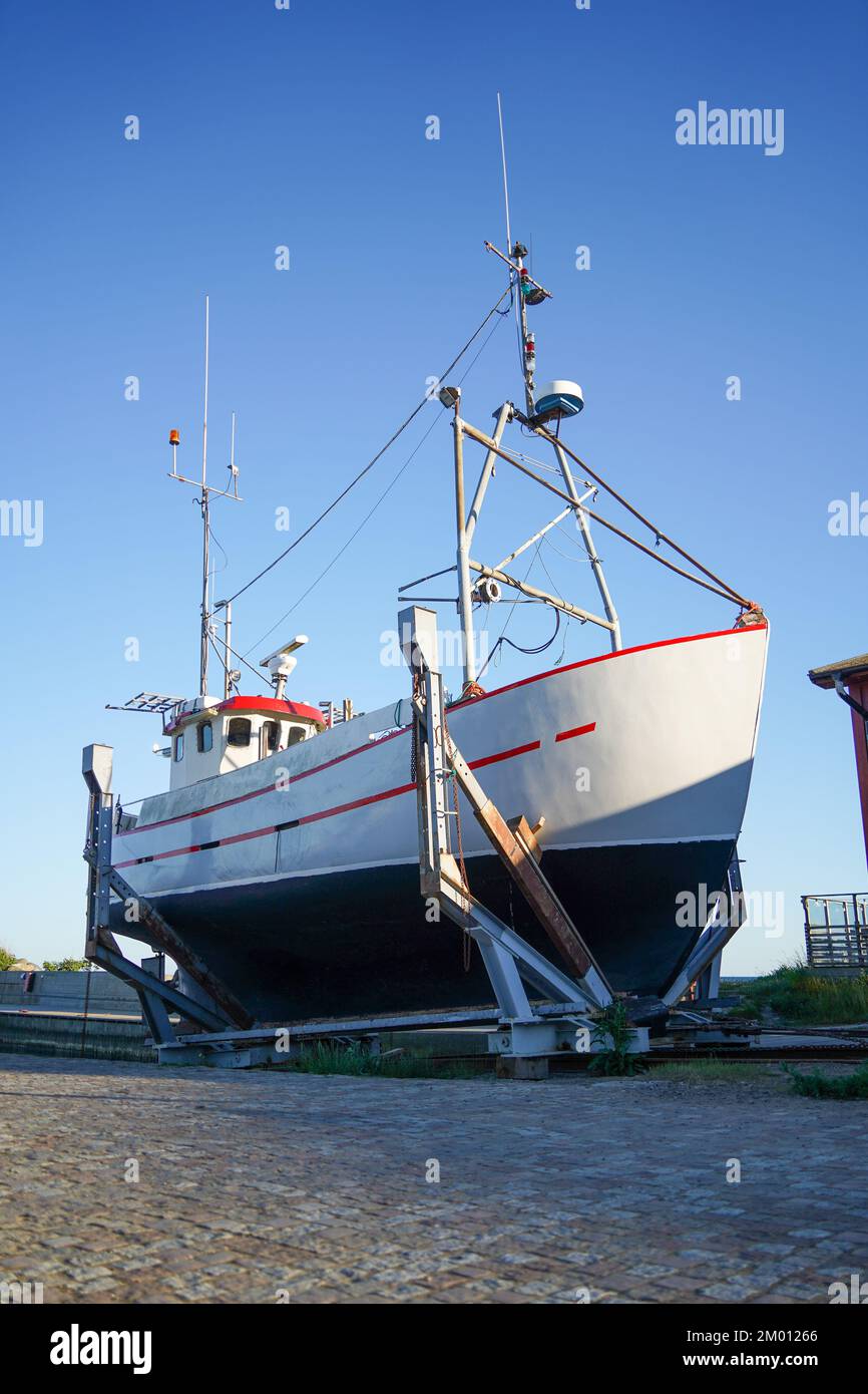 Image du gros bateau à moteur de pêche garé dans l'allée près de la maison Banque D'Images