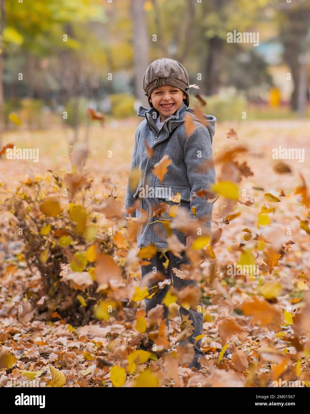Garçon caucasien dans un manteau gris et béret dans la forêt d'automne. Marche d'automne. Banque D'Images Garçon caucasien dans un manteau gris et béret dans la forêt d'automne. Marche d'automne. Banque D'Images