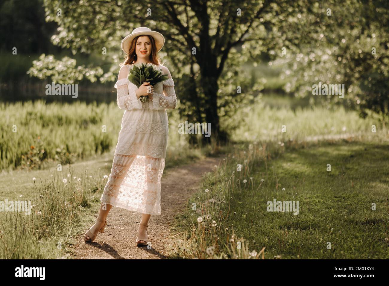 Portrait d'une belle femme dans une robe blanche et un chapeau avec des lys  de la vallée. Une fille dans la nature. Fleurs de printemps Photo Stock -  Alamy