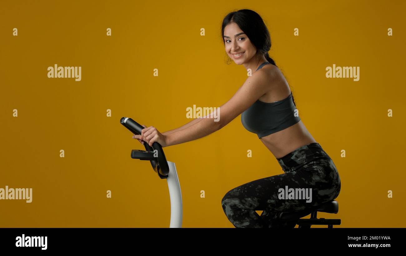 Indienne ethnique forte mince femme sportive femme sportive femme sportive fille sportive vélo flexible vélo sur l'exercice vélo équipement de vélo d'équitation sport fitness entraînement Banque D'Images