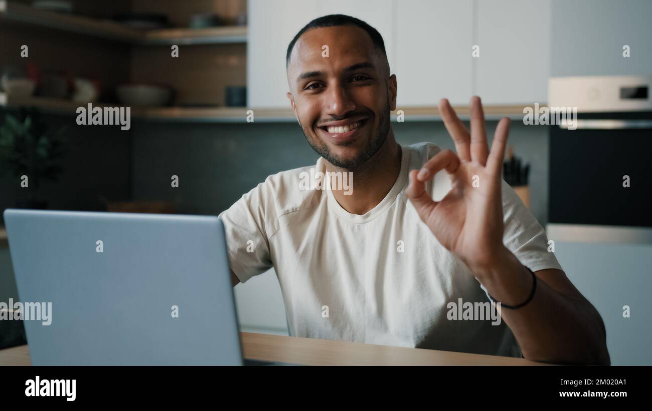 African Latina homme à la cuisine à la maison jouer en ligne navigation dans le pari net travaillant à distance avec l'achat d'ordinateur portable dans la livraison de commande de magasin d'Internet Banque D'Images