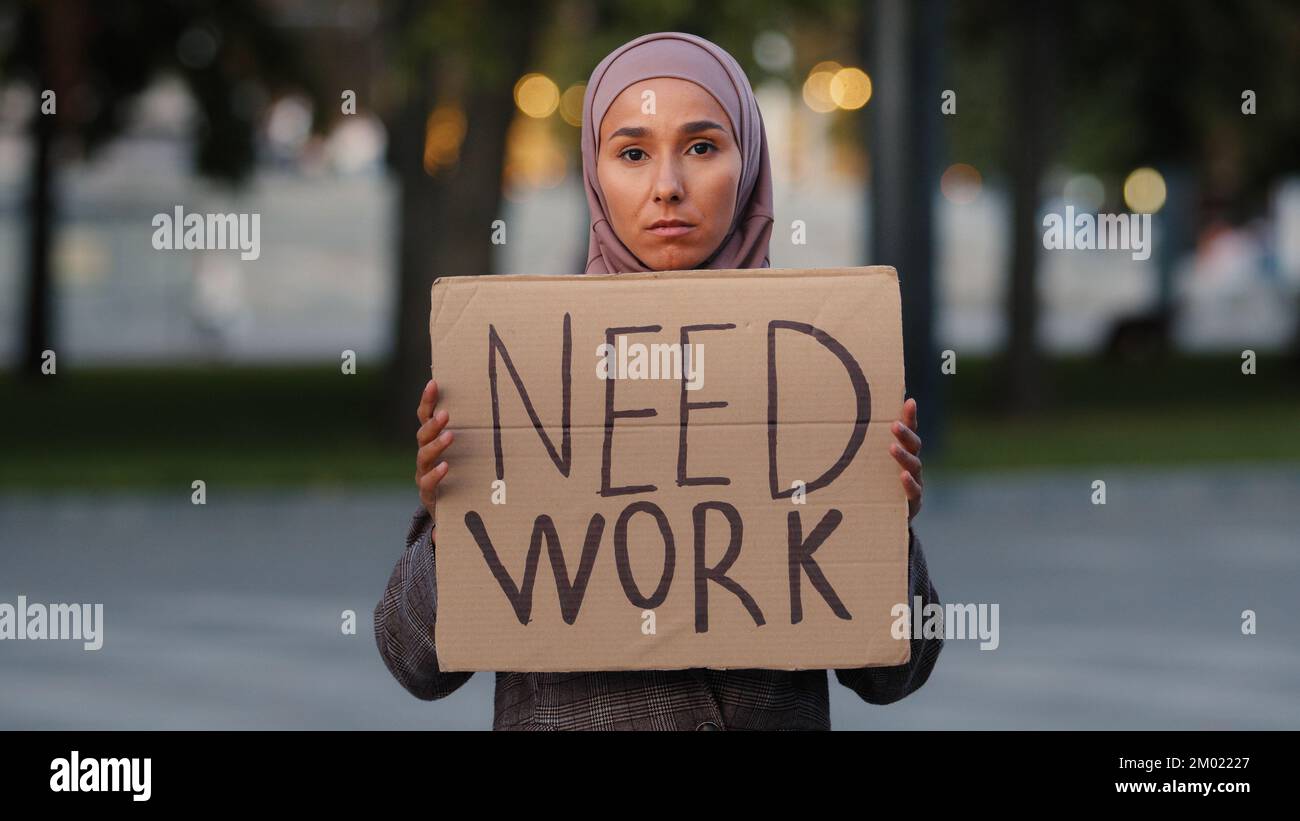 Triste femme musulmane dans hijab debout à l'extérieur islamique fille ethnique bouleversée chômeurs s'inquiéter stressante dame pauvre femme montrant tenant une bannière en carton Banque D'Images